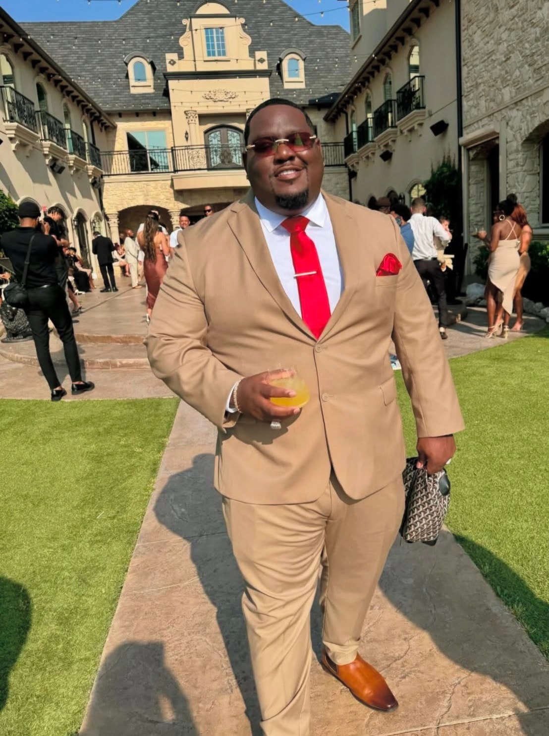 Trail at an outdoor event wearing a tan suit