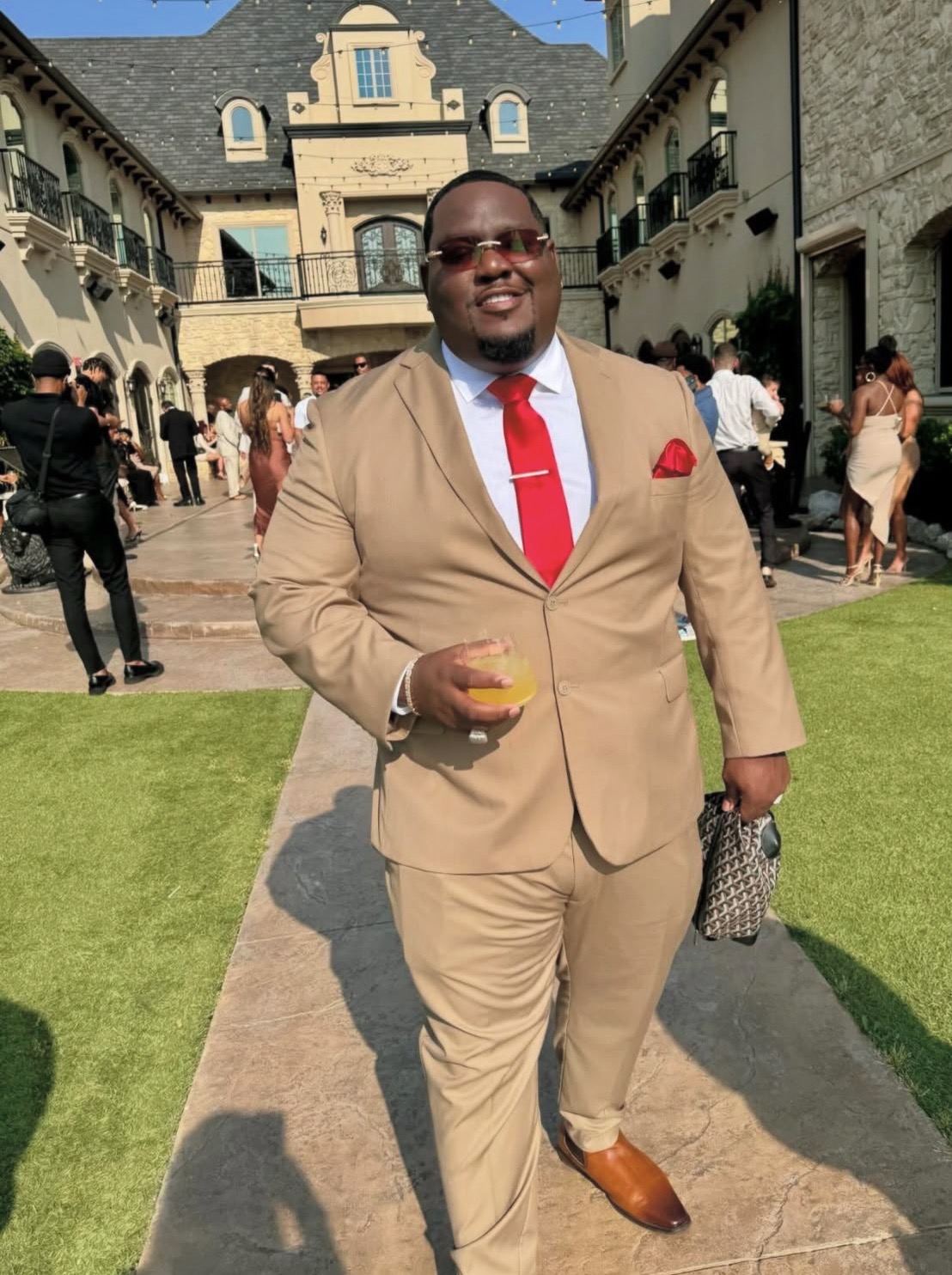 Trail at an outdoor event wearing a tan suit