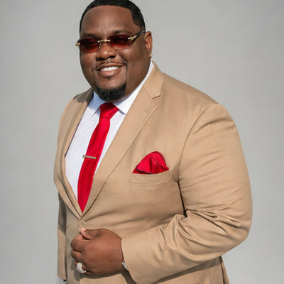 Trail smiling in a tan suit